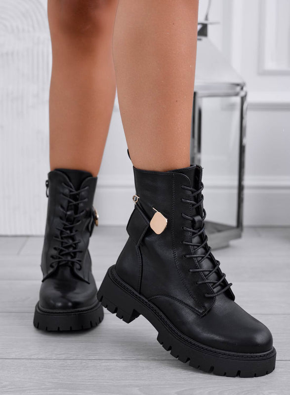 Black ankle boots with gold brooch