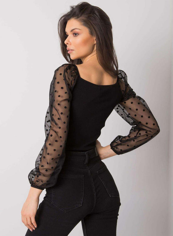 Black top with sheer sleeves and polka dots