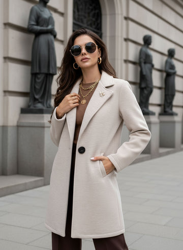 Manteau beige avec bouton noir et broche