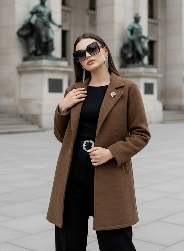 Manteau marron avec bouton noir et broche