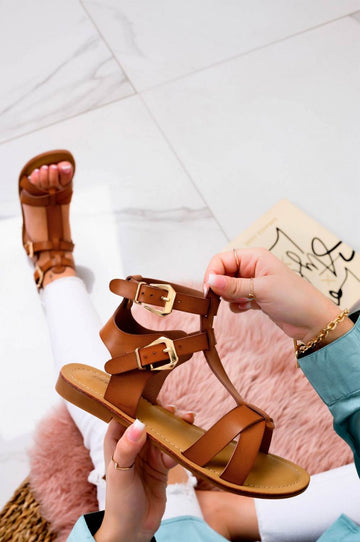 Sandali bassi bianchi fasciati con fibbie oro